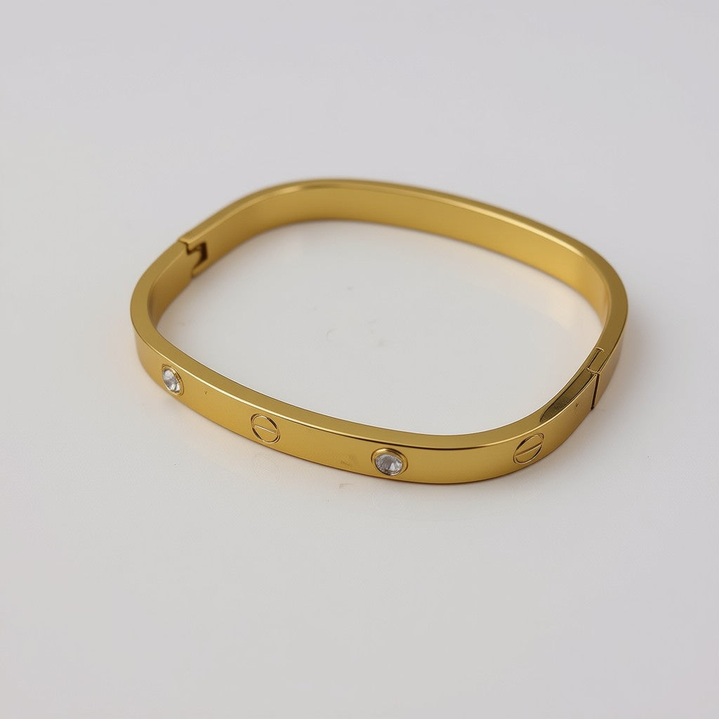 Gold bracelet with embedded stones on a light gray background